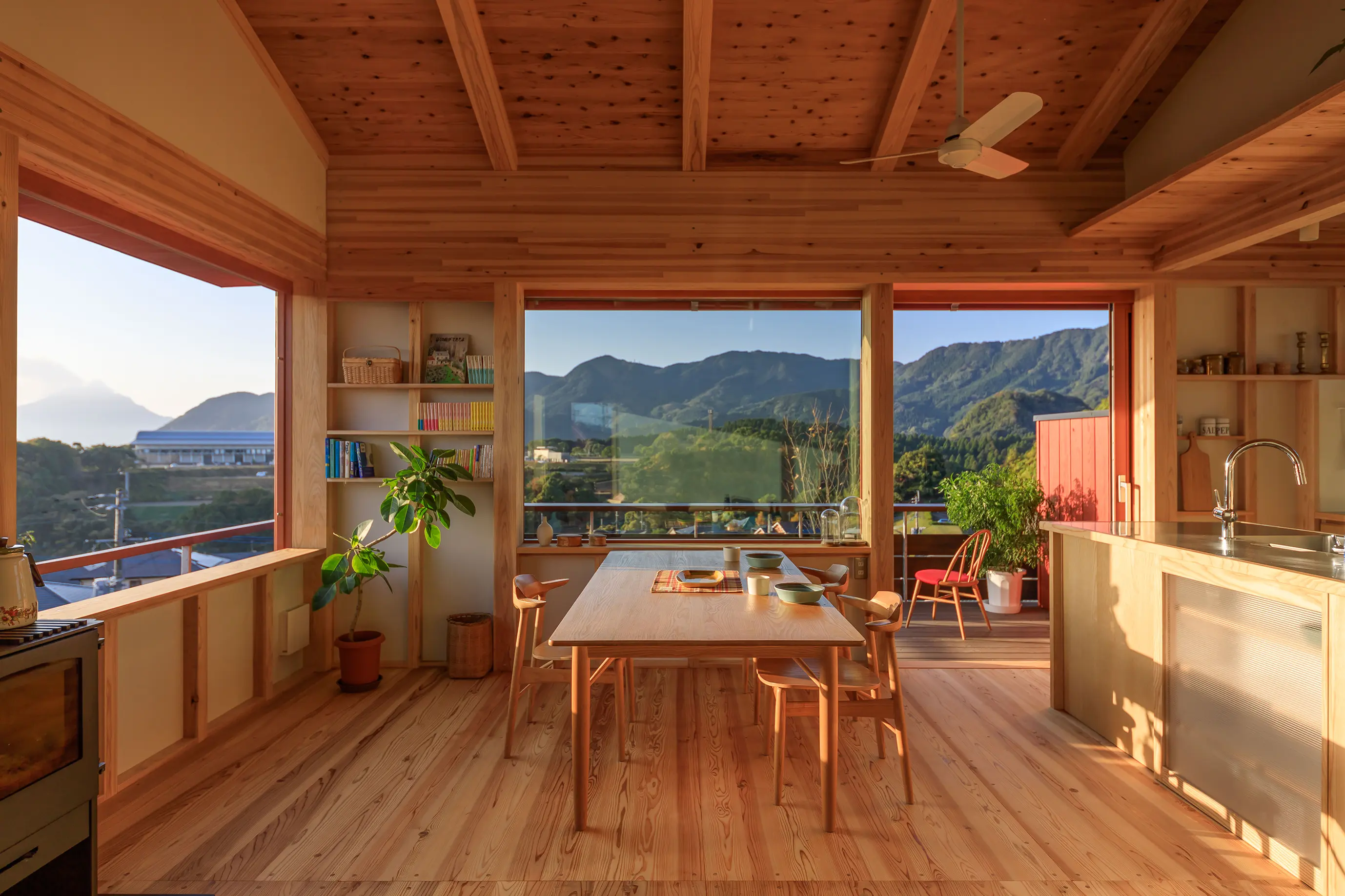 遠くの山並みと空を取り込む絶景リビング。周辺の視線を躱す設計で、カーテンや窓を開けて過ごせます。